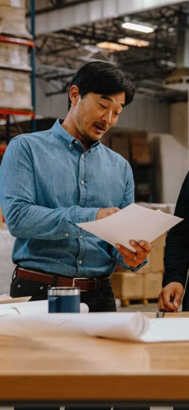 two men discussing paper