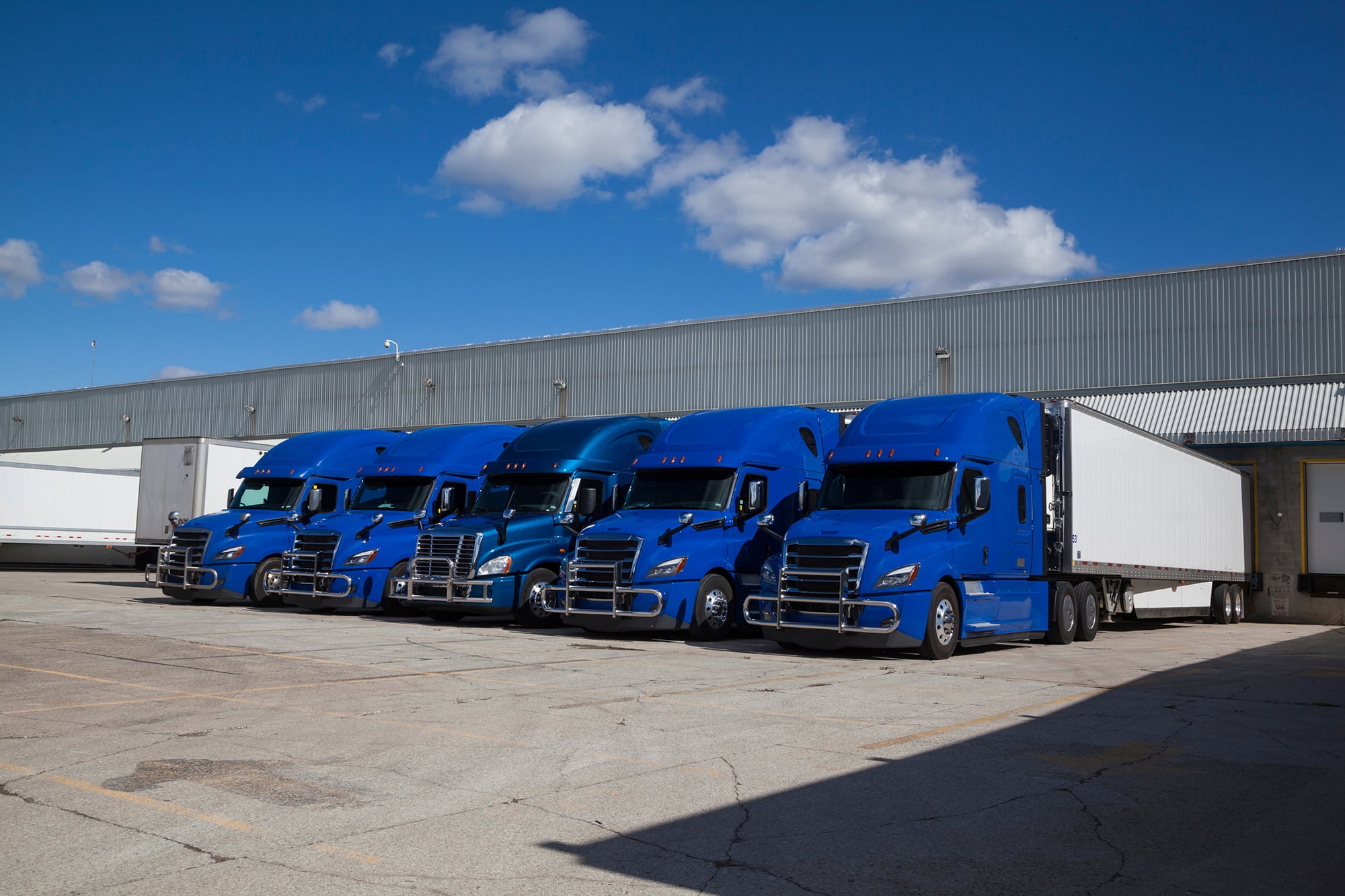 Trucks parked next to each other at a warehouse.